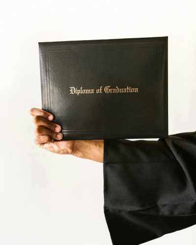 Close-up d'une main tenant un diplôme de fin d'études isolé sur fond blanc