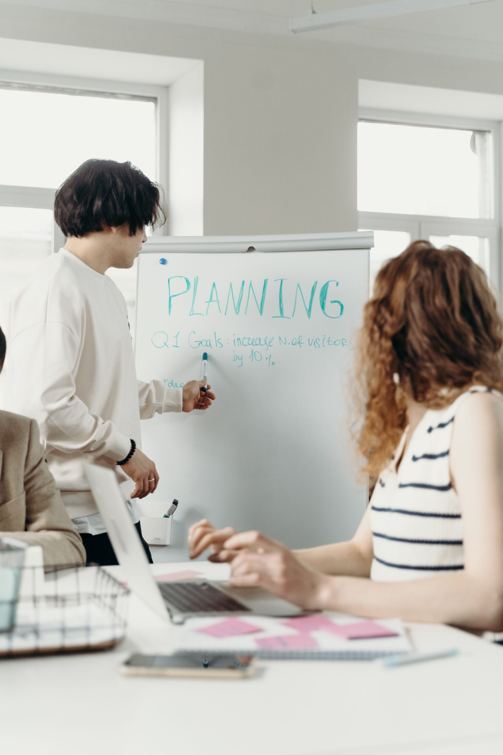 Professional colleagues brainstorming and planning during a business meeting in a modern office setting. Des collègues professionnels qui font du brainstorming et planifient lors d'une réunion d'affaires dans un cadre de bureau moderne.
