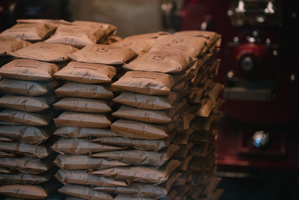 Stacked brown paper packages in an industrial warehouse setting. Perfect for logistics visuals. Paquets en papier brun empilés dans un entrepôt industriel. Parfait pour les visuels logistiques.