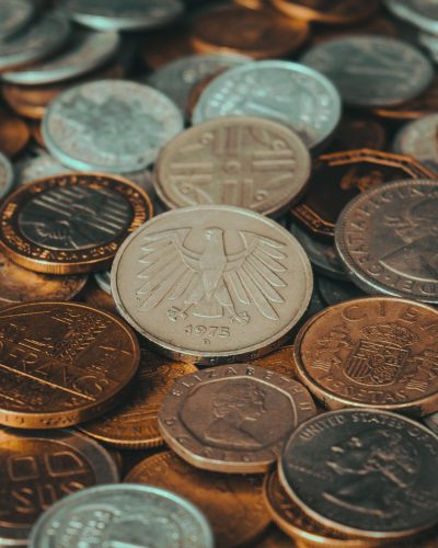 Close-up of various international coins, showcasing diverse currency designs and historical significance. Gros plan sur diverses pièces de monnaie internationales, mettant en évidence des designs de devises diversifiés et leur importance historique.