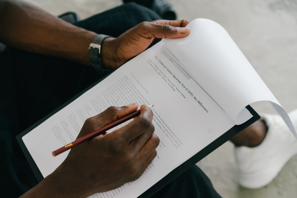 Close-up of a person writing on a psychological assessment form with a pencil. Gros plan d'une personne écrivant sur un formulaire d'évaluation psychologique avec un crayon.