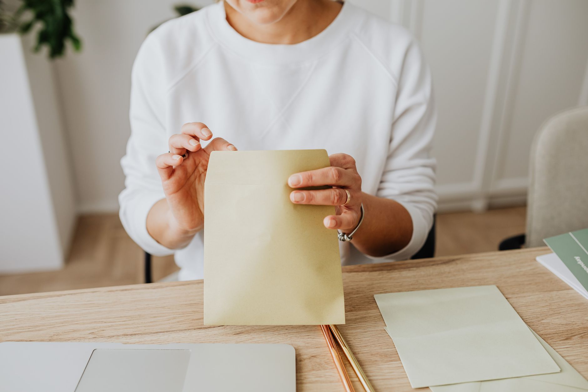 Femme qui scelle une enveloppe sur un bureau en bois