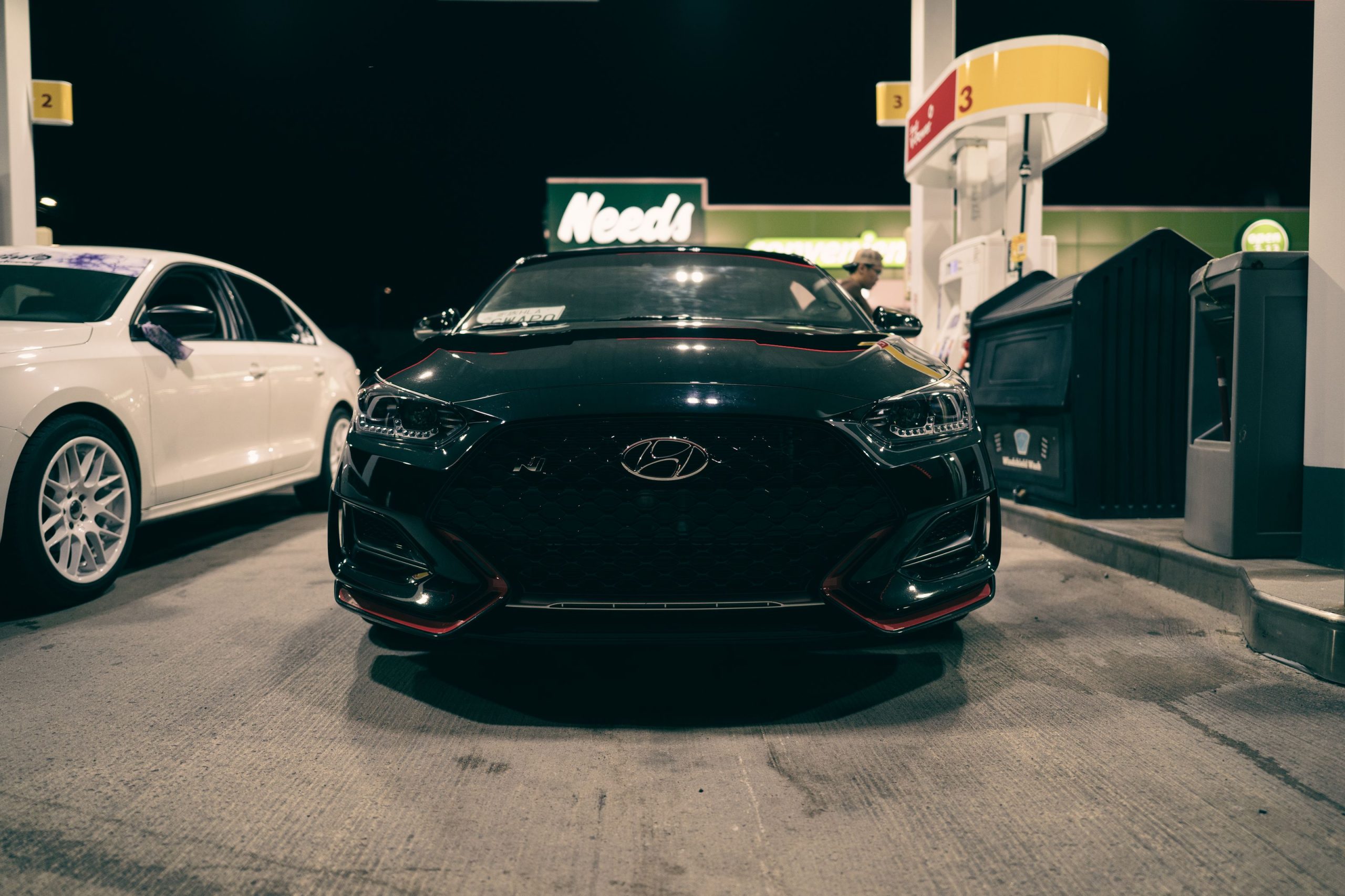 Voiture noire à la station-service de nuit