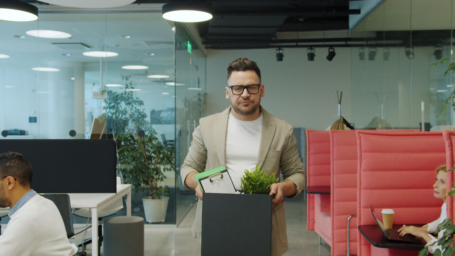 Homme quittant son bureau avec un carton d’affaires